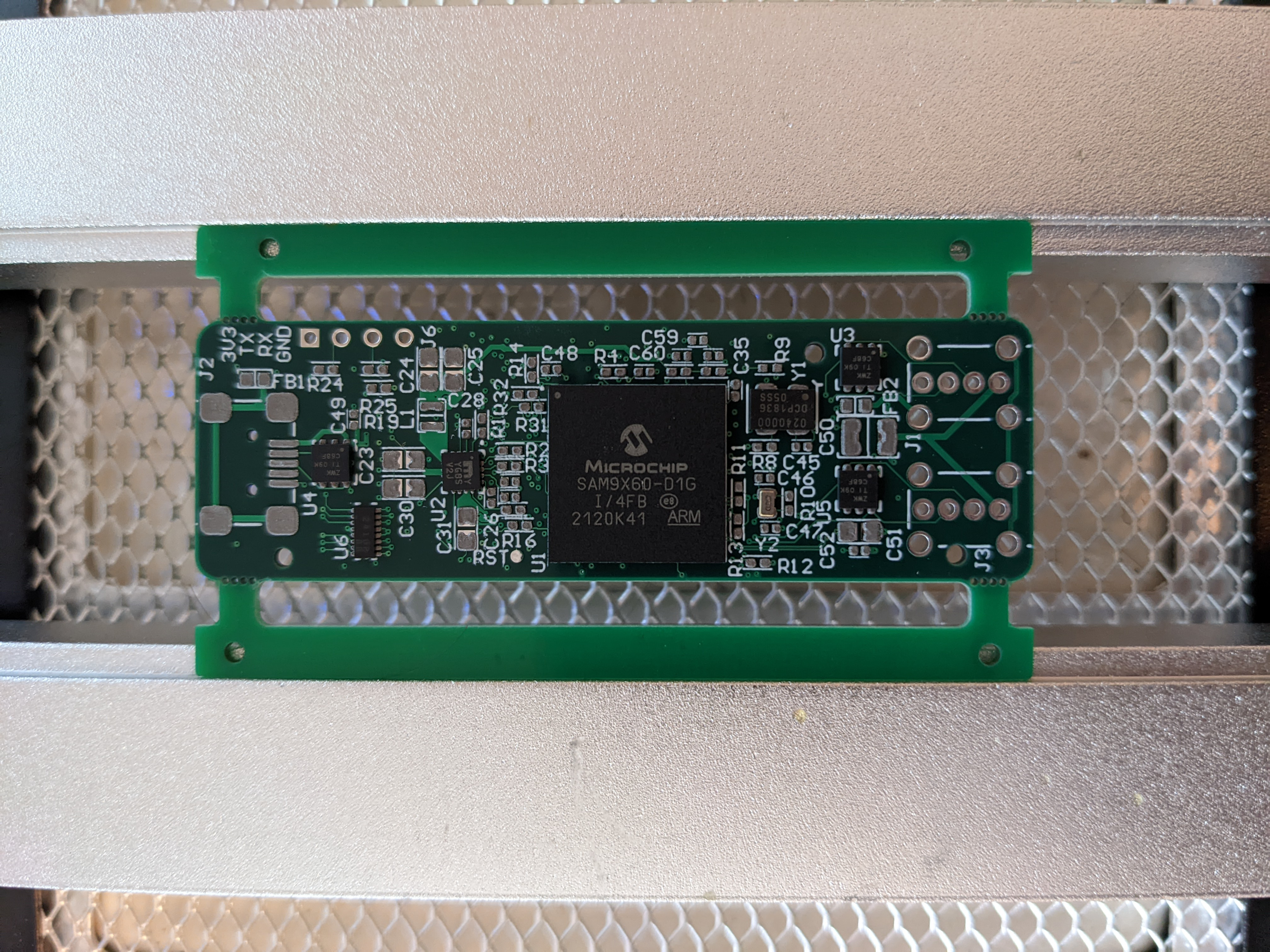 The PCB clamped onto a preheater, with some integrated circuits placed.
